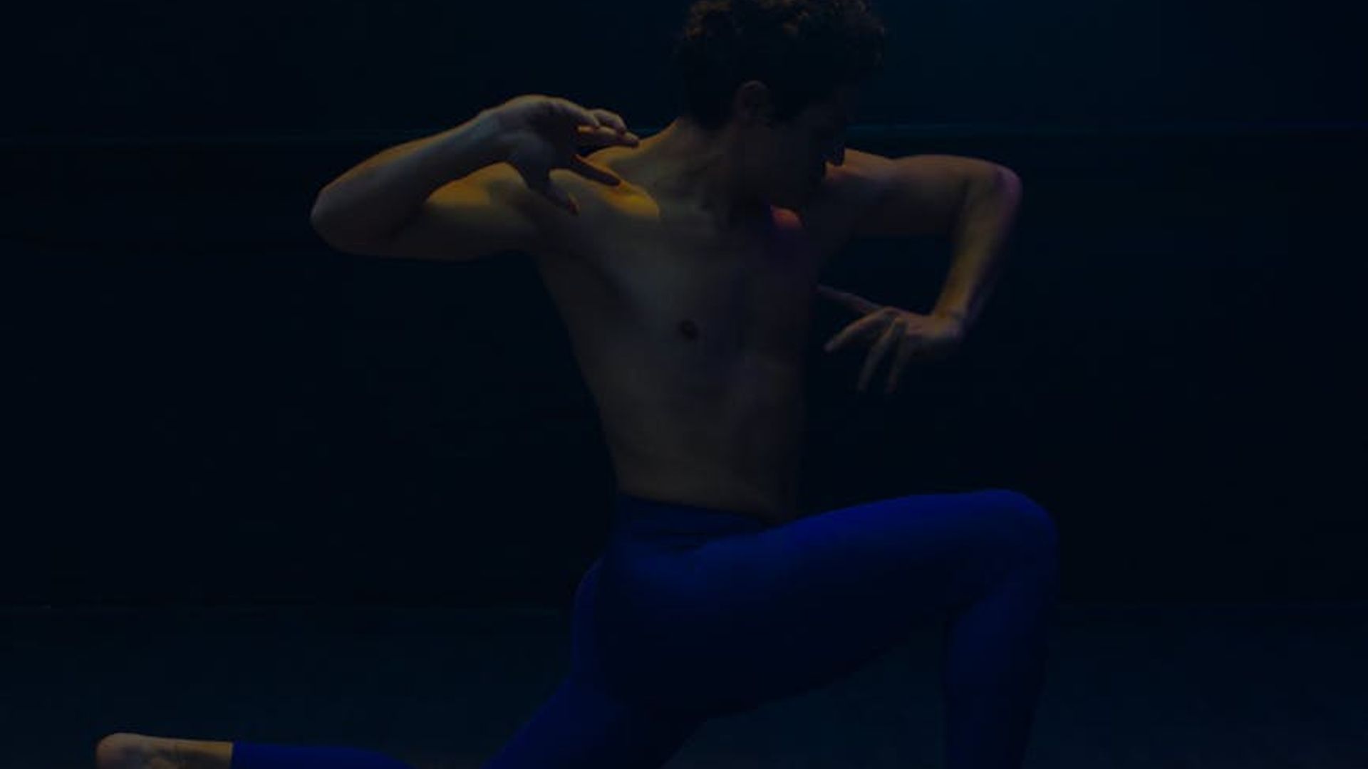 Beautiful dark yoga studio with soft blue neon lighting.